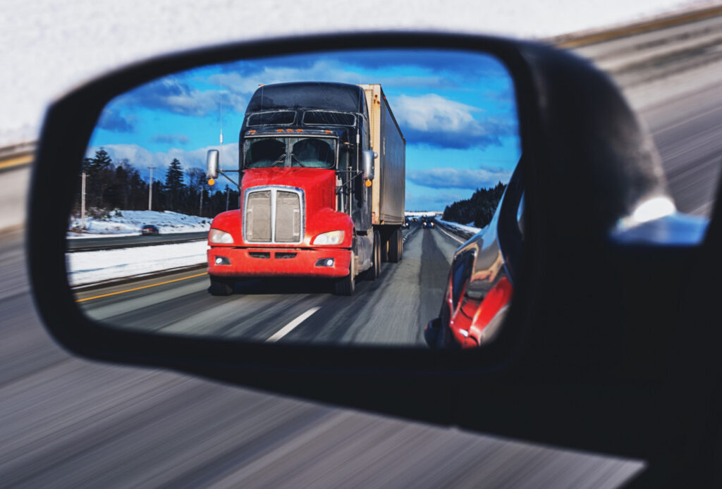 Tailgating truck in car mirror.